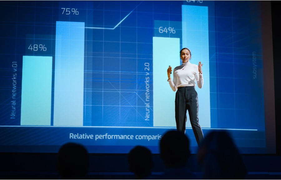 Woman on a stage explaining how principles drives corporate success.